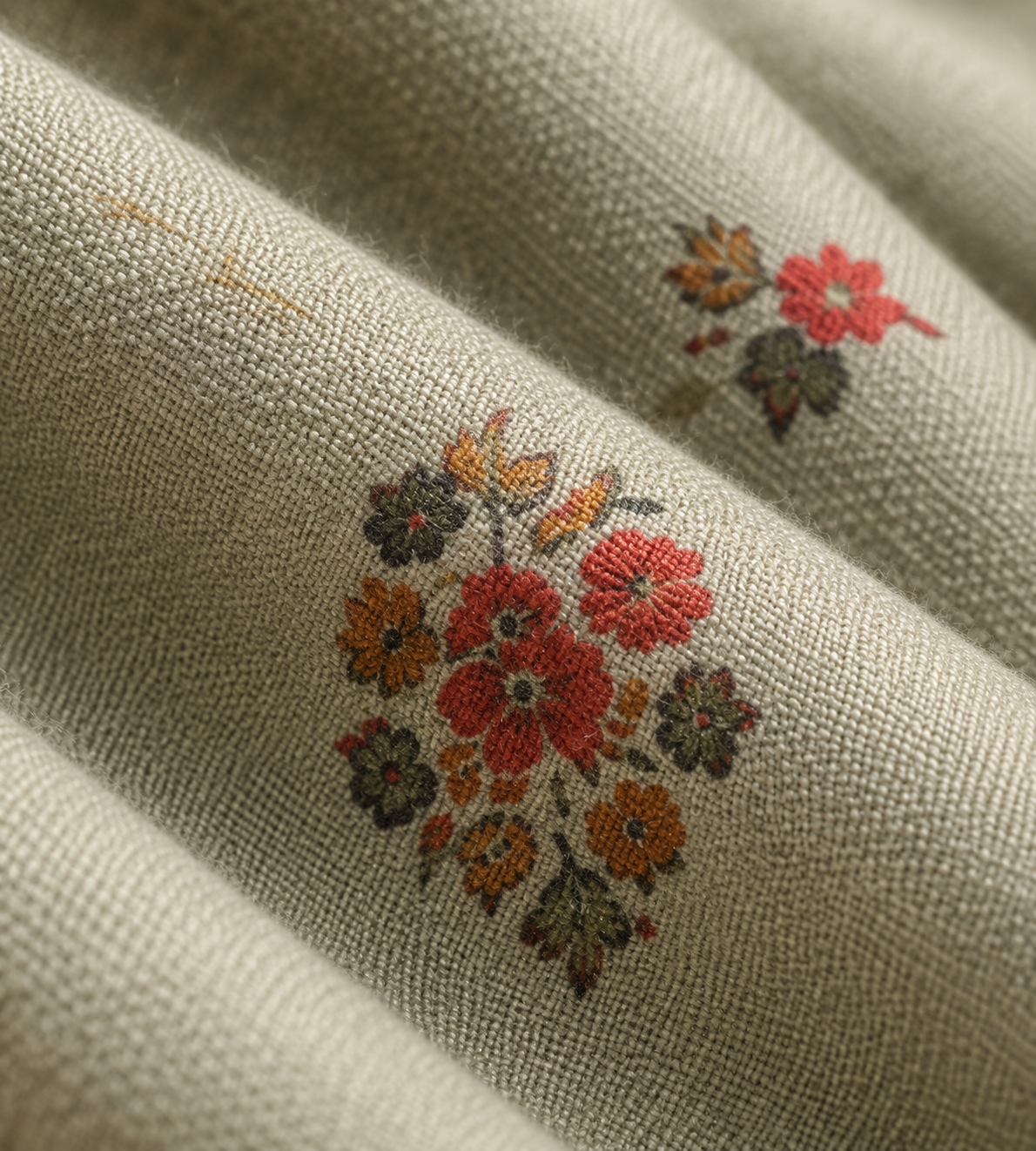 Close detail of the sage fabric's embroidered floral motif.